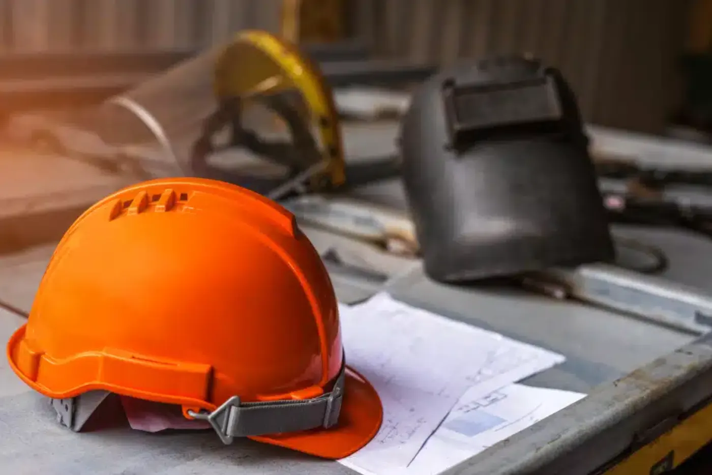 An orange safety helmet resting on site drawings